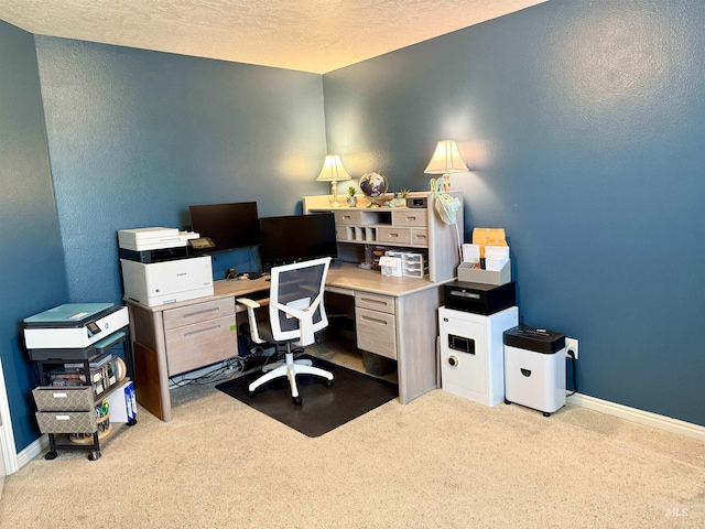 carpeted office featuring a textured ceiling, baseboards, and a textured wall