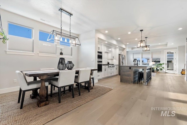 dining space featuring light hardwood / wood-style flooring and sink