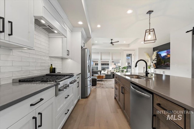 kitchen featuring ceiling fan, sink, hanging light fixtures, white cabinets, and appliances with stainless steel finishes