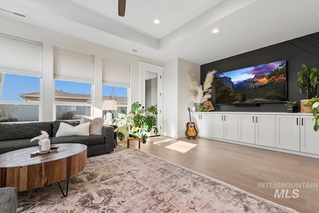 living room with light hardwood / wood-style flooring and ceiling fan