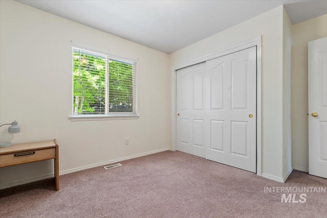 unfurnished bedroom with carpet floors, baseboards, and a closet