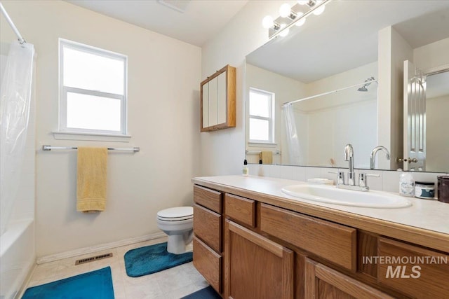 bathroom with toilet, vanity, baseboards, and shower / bath combo with shower curtain