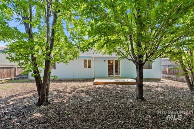back of house with a fenced backyard and a patio