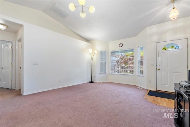 entrance foyer featuring carpet flooring, healthy amount of natural light, vaulted ceiling, and baseboards