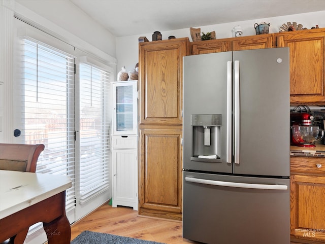 kitchen with light hardwood / wood-style flooring and stainless steel fridge