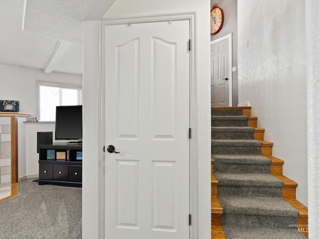 stairway featuring a textured ceiling