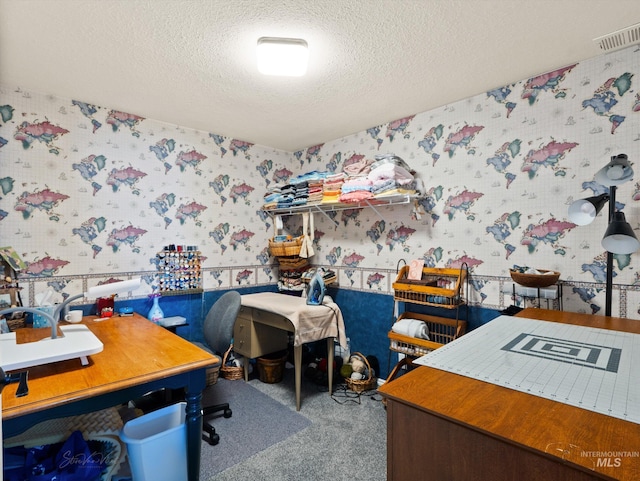 carpeted office featuring a textured ceiling