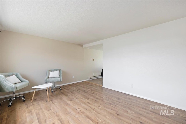 unfurnished room with baseboards, baseboard heating, and wood finished floors
