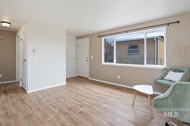 sitting room with baseboards and wood finished floors