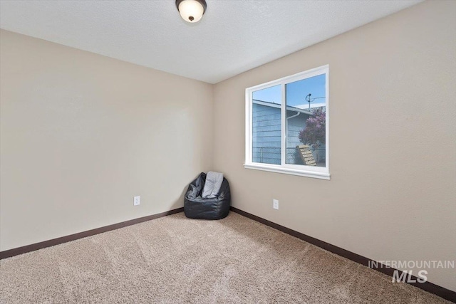 spare room with baseboards and carpet