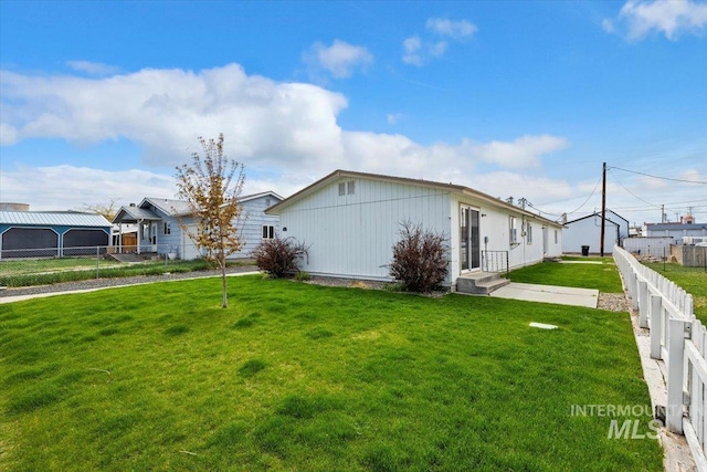 view of side of property with fence and a yard