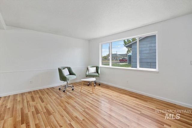 unfurnished room featuring baseboards, a textured ceiling, and wood finished floors