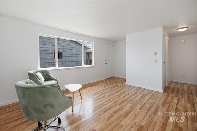 living area with baseboards and light wood-style flooring