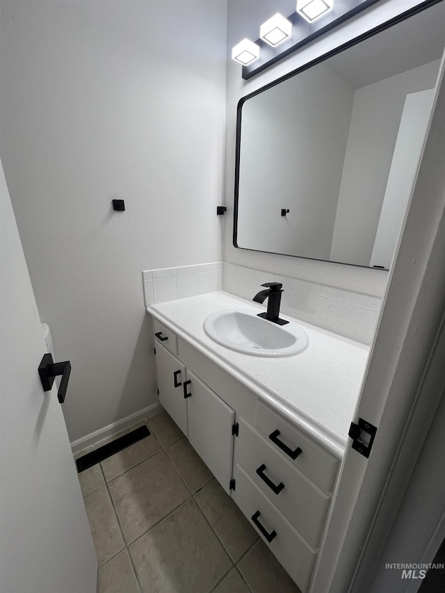 bathroom featuring tile patterned flooring, vanity, and baseboards