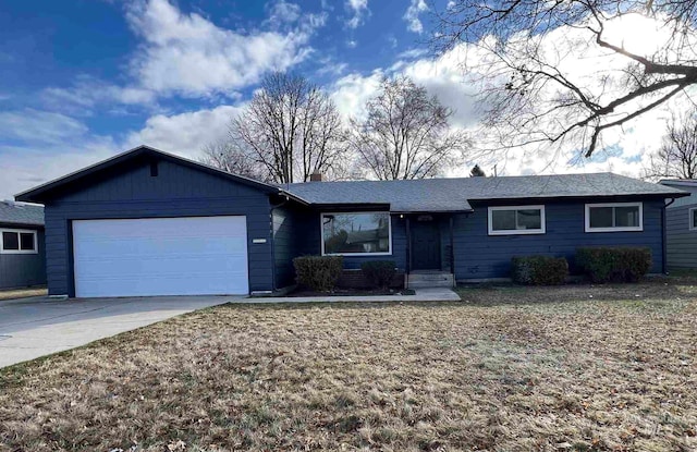 single story home with an attached garage, a chimney, and driveway