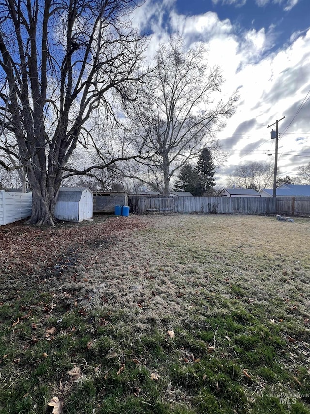 view of yard with an outbuilding, a shed, and a fenced backyard