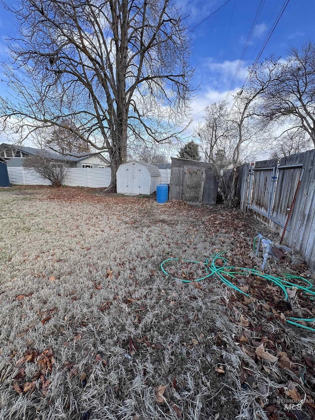 view of yard with a storage unit, a fenced backyard, and an outdoor structure