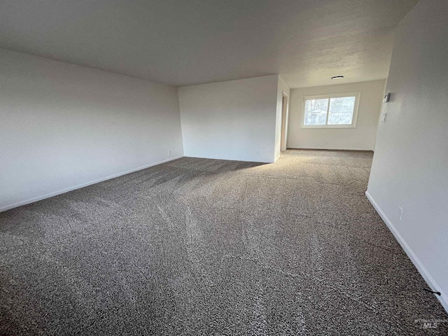 carpeted empty room featuring baseboards