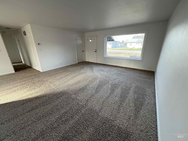 empty room with baseboards and carpet