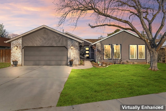 ranch-style house featuring a garage and a lawn