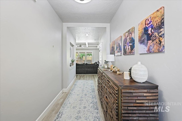 1753 S Kimball Way, Boise, ID 83709 - hall featuring a textured ceiling, light wood finished floors, and baseboards
