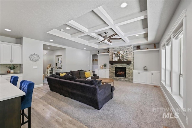 1753 S Kimball Way, Boise, ID 83709 - living room featuring a stone fireplace, light wood-type flooring, coffered ceiling, a ceiling fan, and baseboards