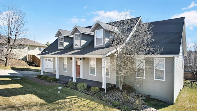 cape cod house featuring a porch, a front yard, roof with shingles, and fence