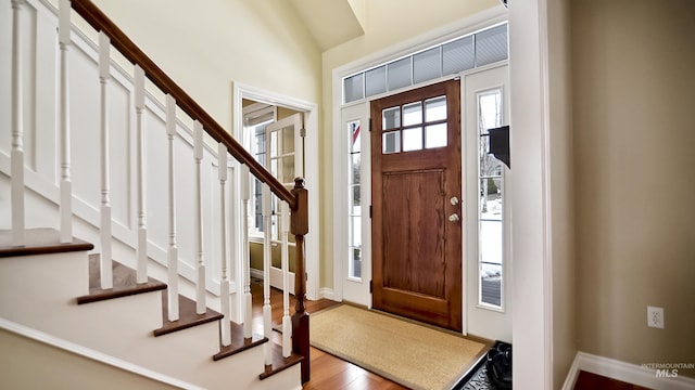 entrance foyer featuring stairs, baseboards, and wood finished floors