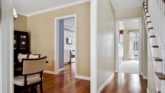 hall featuring stairway, baseboards, ornamental molding, and dark wood-type flooring