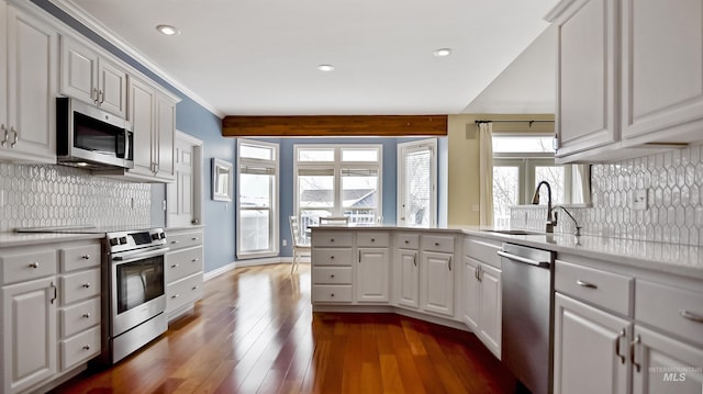 kitchen with white cabinets, hardwood / wood-style flooring, stainless steel appliances, light countertops, and a sink