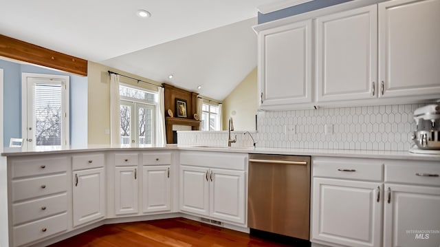 kitchen featuring decorative backsplash, lofted ceiling, a sink, and stainless steel dishwasher