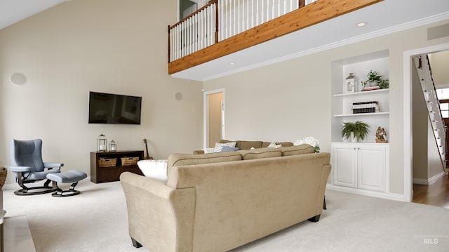 living room with light carpet, built in shelves, a high ceiling, and crown molding