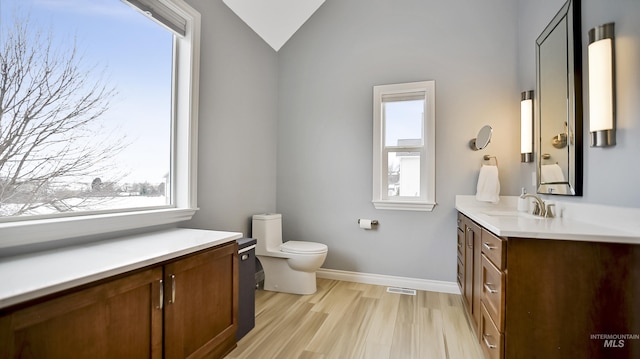 bathroom featuring toilet, plenty of natural light, visible vents, and wood finished floors