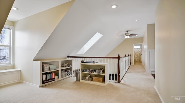 additional living space with recessed lighting, carpet flooring, ceiling fan, vaulted ceiling with skylight, and baseboards