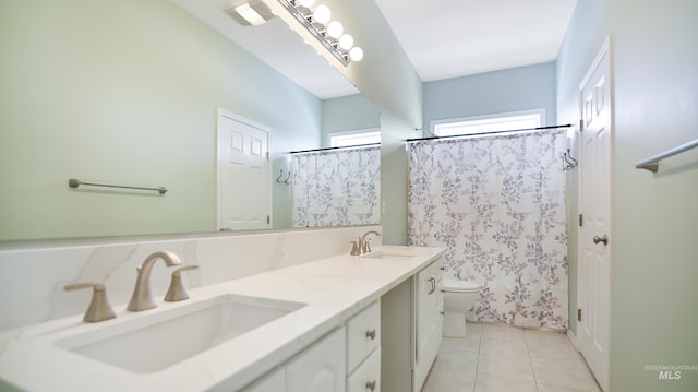 full bathroom featuring double vanity, tile patterned flooring, a sink, and toilet