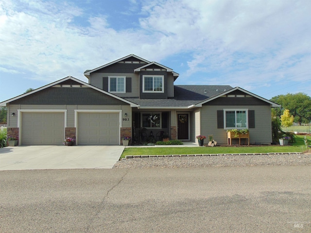 983 S St, Vale, OR 97918 - craftsman house with driveway, an attached garage, stone siding, and a front lawn