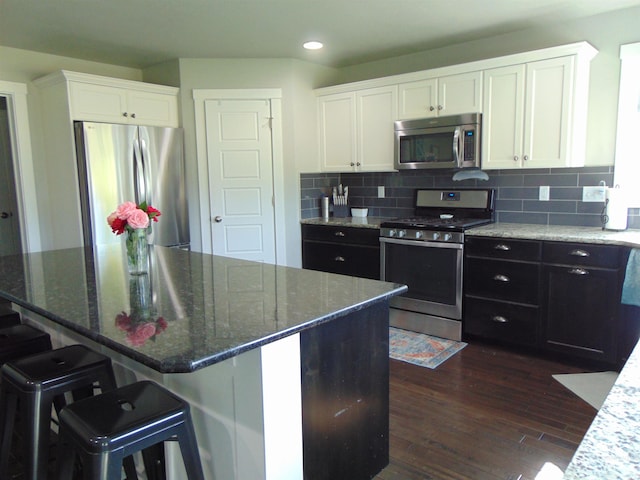 983 S St, Vale, OR 97918 - kitchen with stainless steel appliances, white cabinetry, dark wood-style flooring, dark stone counters, and recessed lighting
