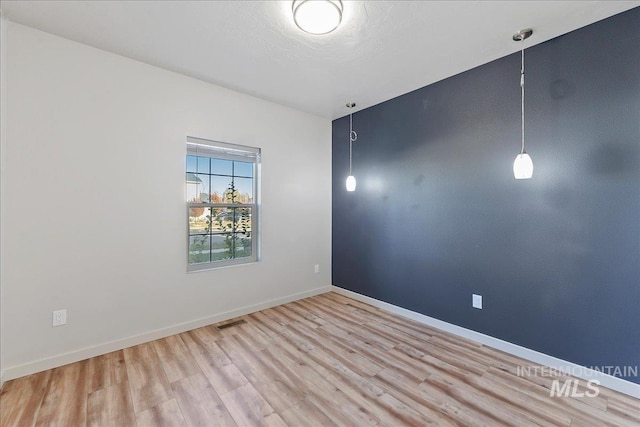 spare room featuring a textured ceiling and light wood-type flooring