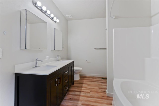 bathroom featuring wood-type flooring, vanity, and toilet