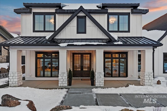 snow covered property entrance featuring french doors