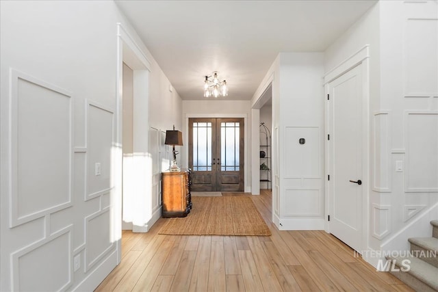 foyer entrance featuring light hardwood / wood-style flooring and french doors