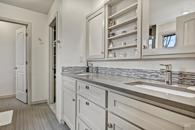 kitchen featuring backsplash, sink, and white cabinets