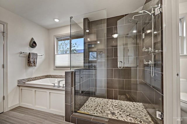 bathroom with hardwood / wood-style flooring, toilet, and independent shower and bath