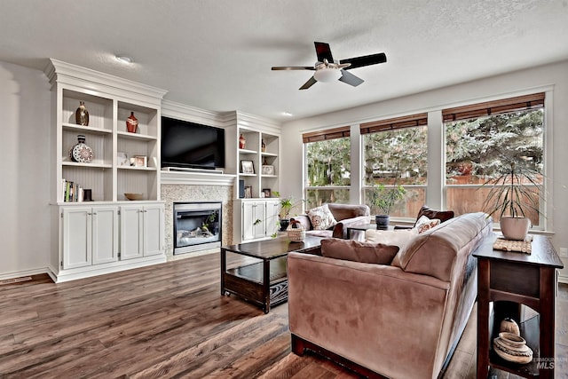 living room with ceiling fan, dark hardwood / wood-style floors, and a textured ceiling