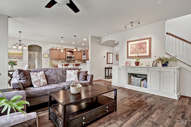 living room featuring ceiling fan and dark hardwood / wood-style flooring