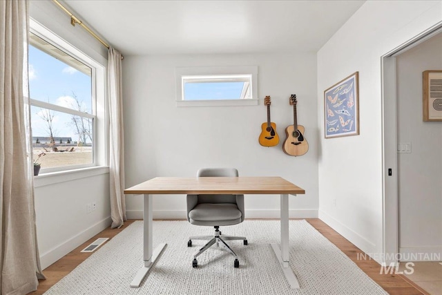 home office featuring visible vents, baseboards, and wood finished floors