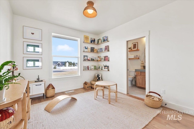 interior space featuring light wood-type flooring and baseboards