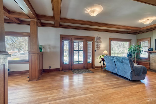 entryway featuring light wood-style flooring, a fireplace, baseboards, and coffered ceiling