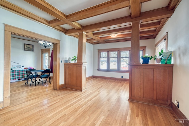 interior space featuring baseboards, coffered ceiling, light wood finished floors, beam ceiling, and a notable chandelier