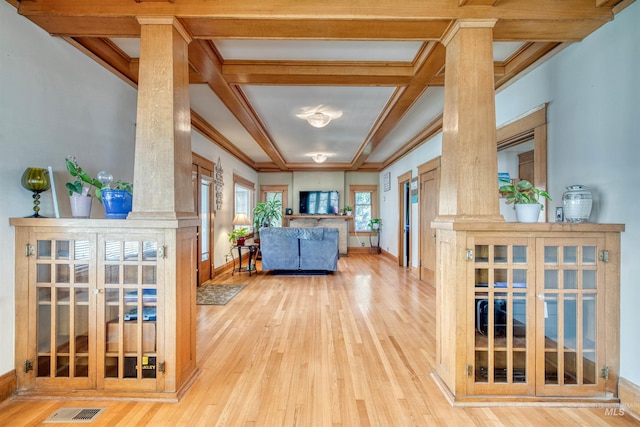 living area with wood finished floors, visible vents, coffered ceiling, baseboards, and crown molding